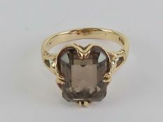 A 9ct gold smoky quartz cocktail ring, the octagonal cut quartz approx 4.6ct (measuring approx 9.