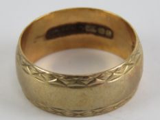 A 9ct gold ring having engraved border pattern, hallmarked 375, size N, 3.9g.