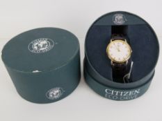A Citizen wristwatch having leather faux crocodile skin strap, in box.
