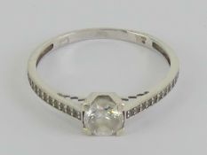 A 9ct white gold and cz ring having central round cut stone to centre with smaller stones to