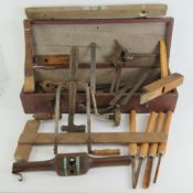 A vintage wooden tool box with leather handle containing a quantity of assorted vintage tools.