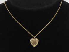 A 14ct gold locket in the form of a heart, having floral engraving to front, stamped 14k, 1.