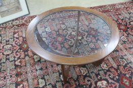 A mid 20th century G-Plan Astro circular coffee table having glass insert over quatroform base,