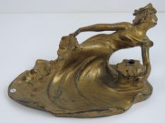 A gilded spelter Art Nouveau inkwell in the form of a recumbent female, 20cm wide,