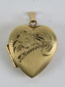 A 9ct gold locket in the form of a heart having partial floral engraving to front, hallmarked 375,