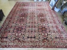A woollen and silk rug in reds and browns having geometric decoration upon 300 x 220cm.