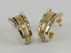 A pair of 9ct white and yellow gold earrings having trio of cz stones, 3g.