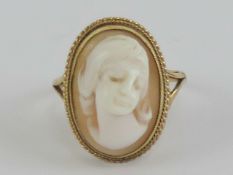 A 9ct gold ring a having oval carved shell female cameo in rope twist setting, hallmarked 375,