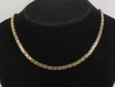 A 9ct gold articulated half hoop and bar chain necklace measuring 42cm in length,
