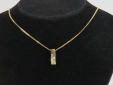 A 9ct gold pendant in the form of two bars, each set with square cut cz stone,
