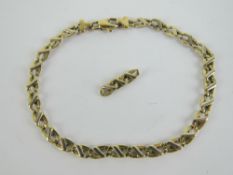 A 9ct gold bracelet having white bar on yellow oval links,