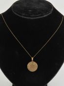 A 9ct gold round locket having engraved patterned front, opening to reveal two compartments within.