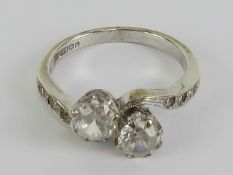 A 9ct white gold crossover ring having twin round cut white stones with further smaller white