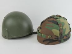 Two helmets one having camouflage fabric