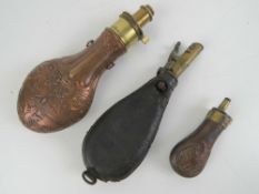 A copper and brass powder flask marked G