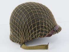 A WWII US Army McCord helmet having heat strap that dates it to 1945,
