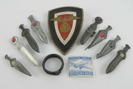 A replica WWII German day badge, together with eight badges in the form of daggers,