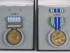 Two US military medals in boxes; Korea (bar deficient), and another for military achievement.