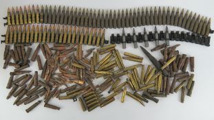 A large quantity of assorted inert bullets some on a machine gun belt.