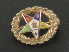 Masonic; A 10ct gold enamelled pentagram a wreath pin or brooch, stamped 10k, 15mm wide.