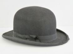 A vintage bowler hat with leather and si