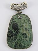 A large green hardstone pendant having h