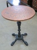 A circular beaten copper pub style table