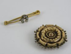 A yellow metal pin brooch having horsesh