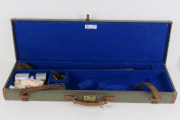 A 20th century canvas covered 12 gauge shotgun case, leather handle, twin straps, brass lock,