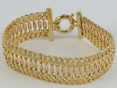 A 9ct gold three row articulated link bracelet having central oval polished links with planished