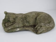 A precast stone garden figurine sleeping cat, 40cm in length.