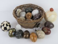 A basket containing a quantity of marble and papier mache eggs, an onyx sphere, etc.