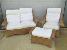 A wicker conservatory suite, late 20th century, two seater settee, chair and footstool,