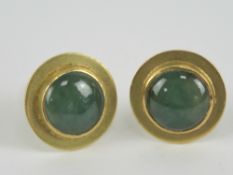 A pair of yellow metal stud earrings having green and white jade cabachon to centre,