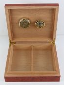 A humidor having hygrometer and internal divider, measuring 24 x 22 x 7cm.