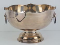 A silver on copper hand chased punch bowl of plain but traditional form having lion mask handles