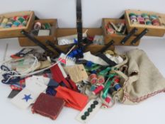 A c1930s cantilever sewing box containing a large quantity of sewing ephemera, needles, threads,