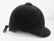 A velvet covered peak riding hat as made by Lock & Co London, size 7.