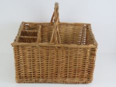 A wicker picnic basket having loop handle and dividers to hold three bottles, 48 x 38cm.