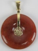 A 14ct gold red jade disc pendant having Chinese character to centre, 2.3cm dia, stamped 14k.