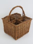 A four sectional wicker picnic wine basket with integral woven hoop handle, 36cm high.
