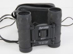 A pair of folding 8 x 21 Hawke binoculars with leatherette carry pouch.