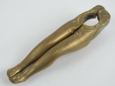 A 'risque' hinged bottle opener in the form of a pair of shapely female legs, 12cm in length.