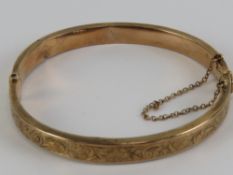 A vintage rose metal hinged bangle having makers mark and partial (18?) mark upon,