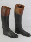A pair of black and brown leather riding boots,