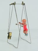 A Jitsuyo O Shinan Japanese clockwork trapeze acrobat, celluloid doll on a metal frame, c1930-50s,