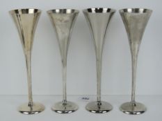 Links of London; a set of four silver plated champagne flutes, each standing 25cm high.