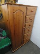 A pine cupboard having single door and six short drawers.