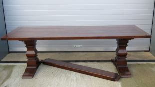 A fine heavy solid oak four plank trestle dining table raised over substantial squared baluster