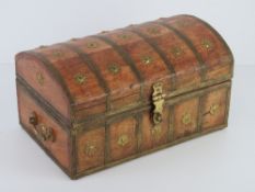 A wooden domed top lidded casket with gilt brass ornamentation throughout,